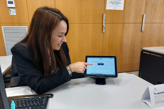 Una trabajadora de Atención al Cliente muestra la tablet donde se realizan las gestiones. 